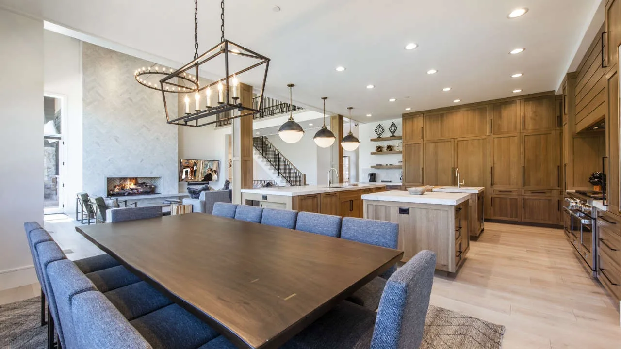 An open kitchen and dining area with a large table and wood cabinetry.