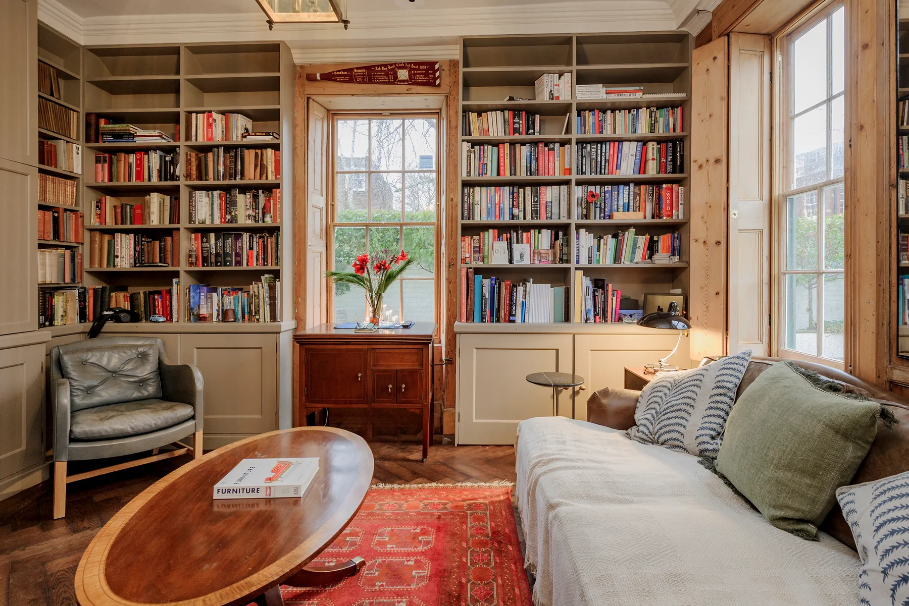 A living room with built-in bookshelves, a sofa, and a patterned rug.