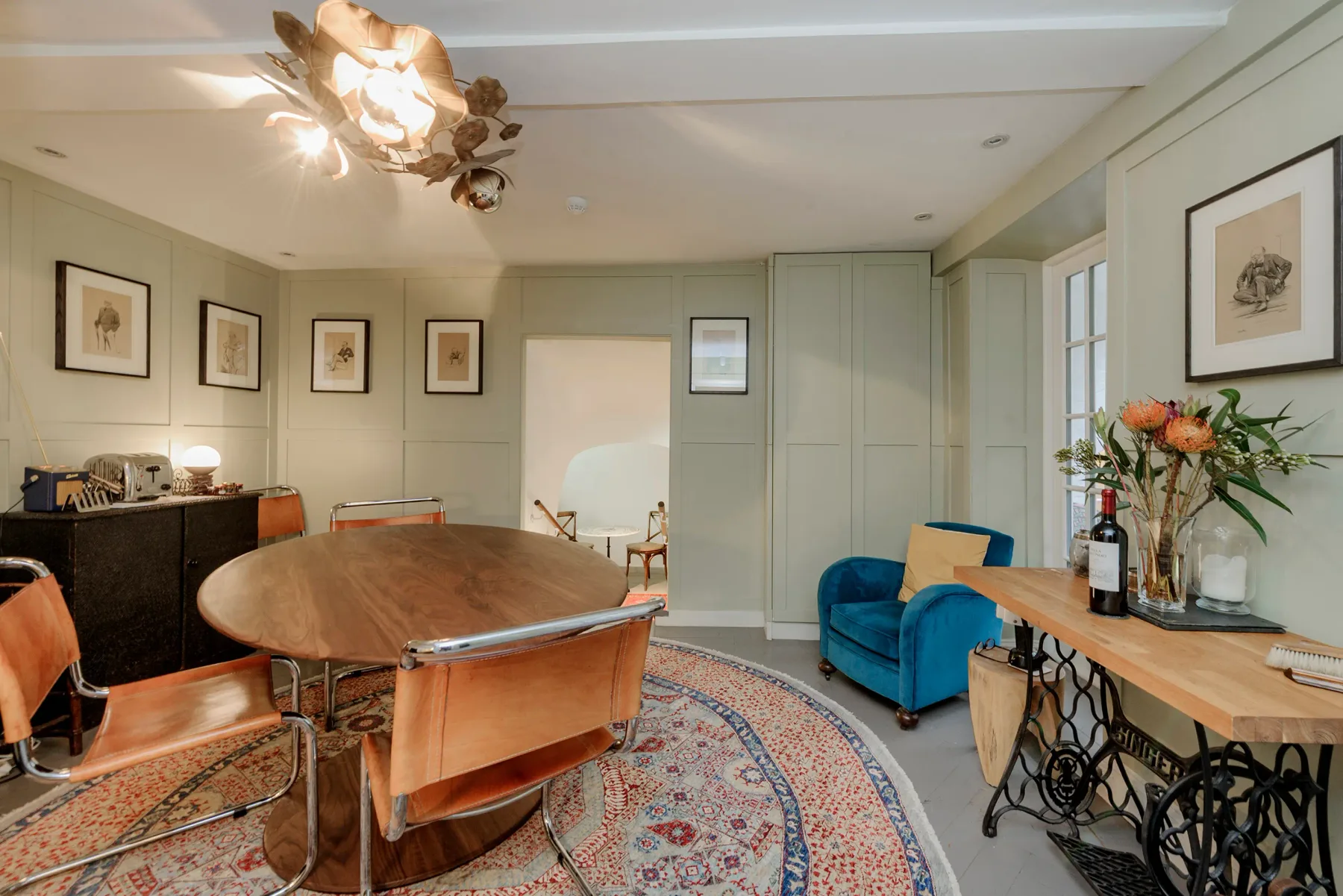 A dining and sitting room with a large oval table and blue seating.