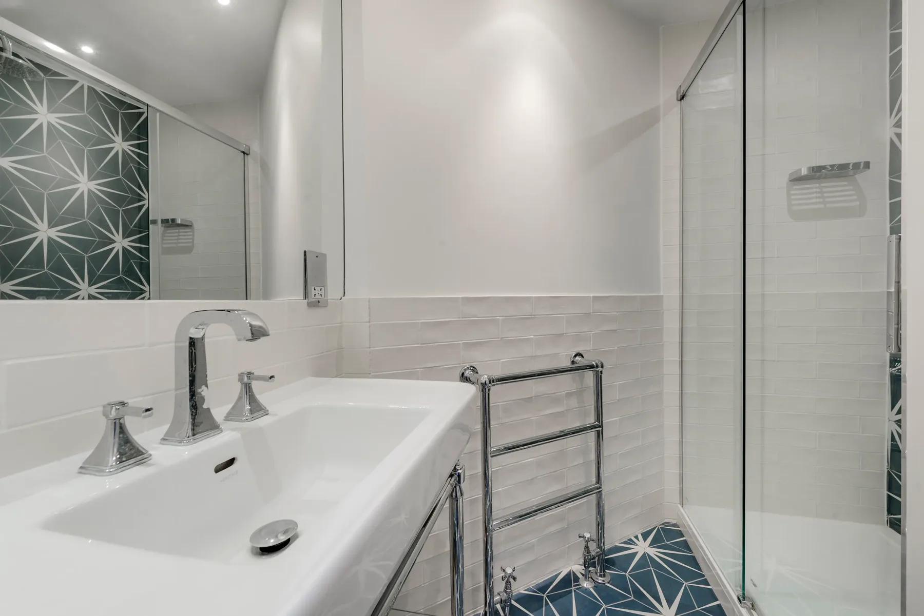 A modern bathroom with a sink and glass shower.