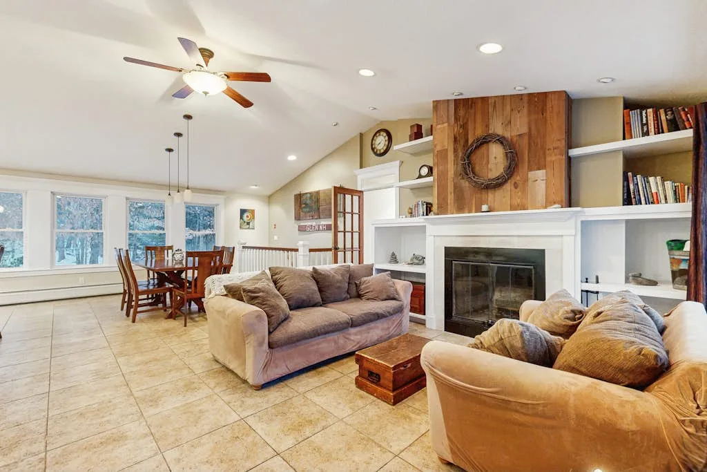 A living room with seating arranged around a fireplace and adjoining dining area.