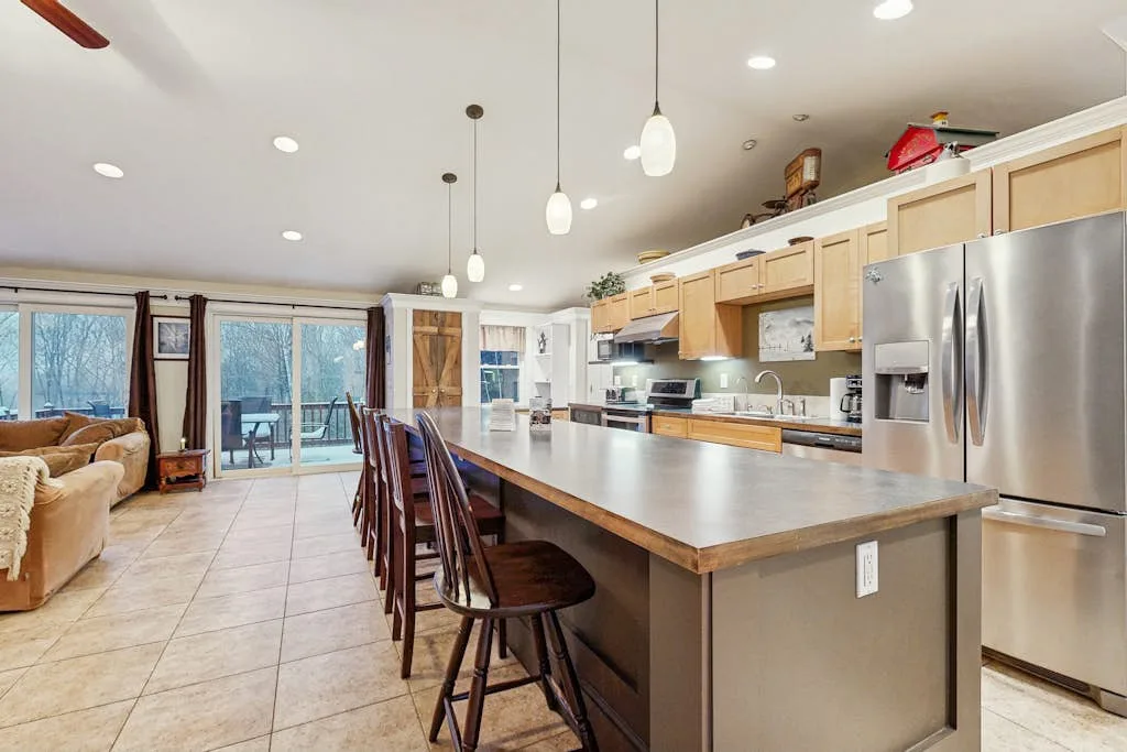 Cocina y sala de estar de concepto abierto con una isla grande y asientos de barra.