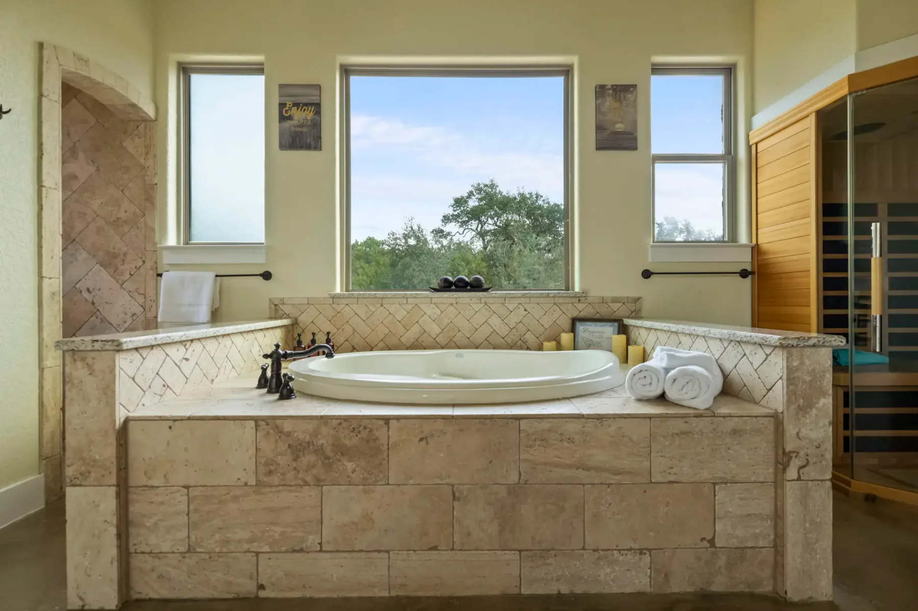 Luxurious bathroom with a central bathtub, large windows, and neatly arranged towels, creating a serene and inviting atmosphere.