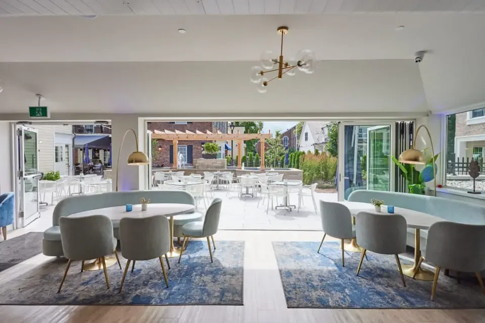 Restaurant interior with windows opening onto an outdoor patio.