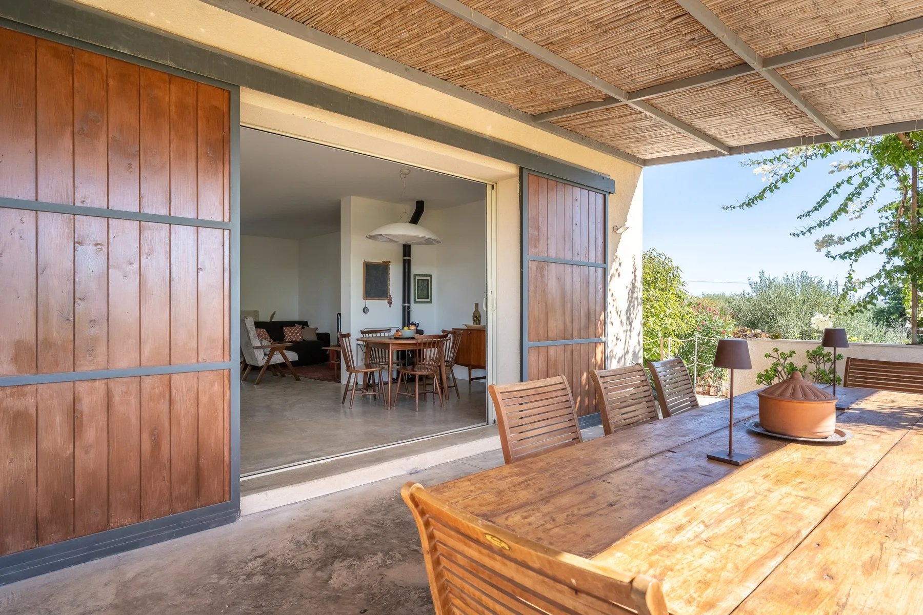 Una zona de comedor exterior cubierta se abre a un comedor interior.
