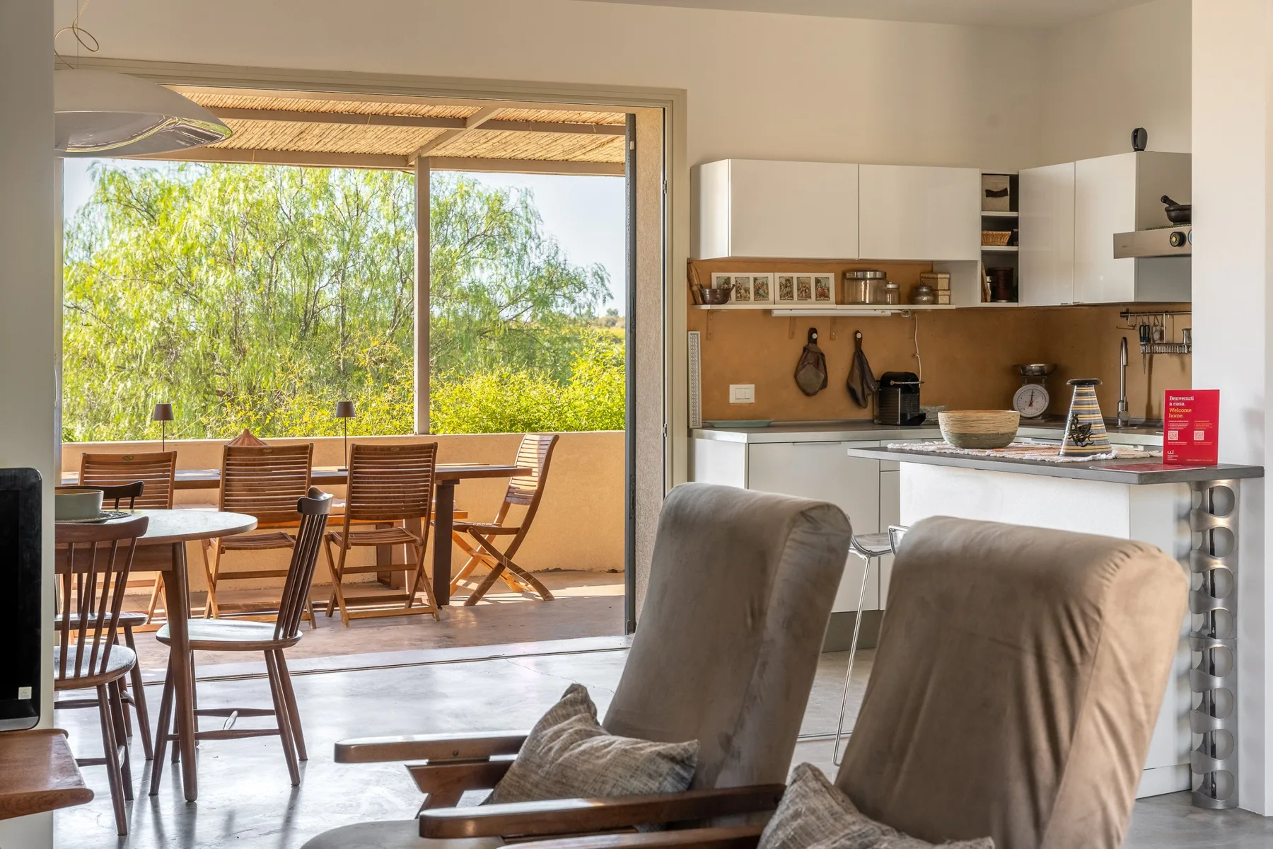 Una luminosa cocina y comedor se abre a una terraza cubierta con asientos al aire libre.