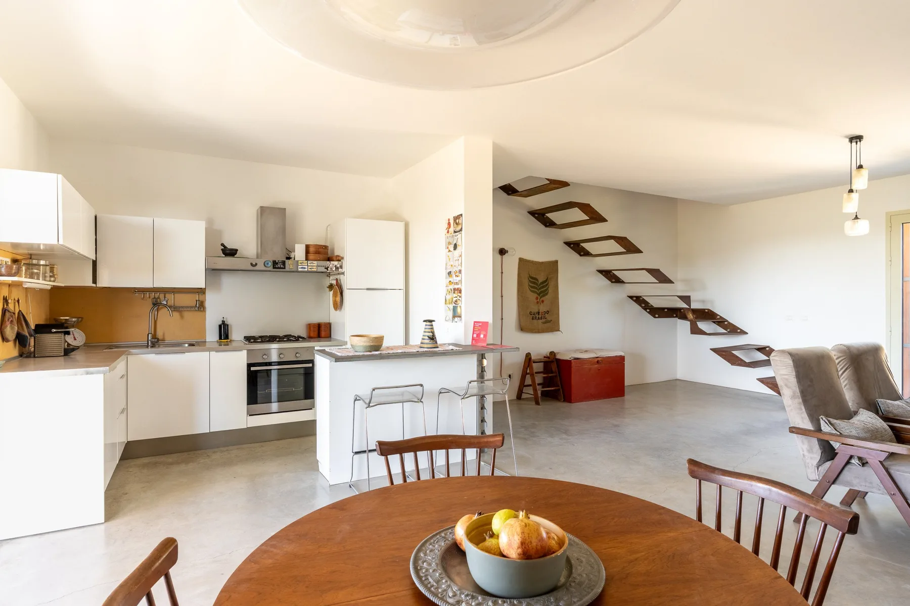 Una cocina y comedor diáfanos con una mesa en primer plano.