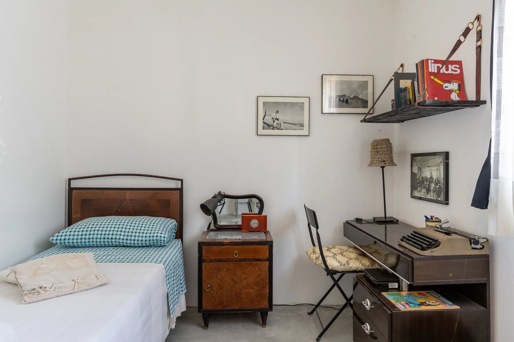 Un dormitorio con una cama individual, una mesita de noche y un escritorio.
