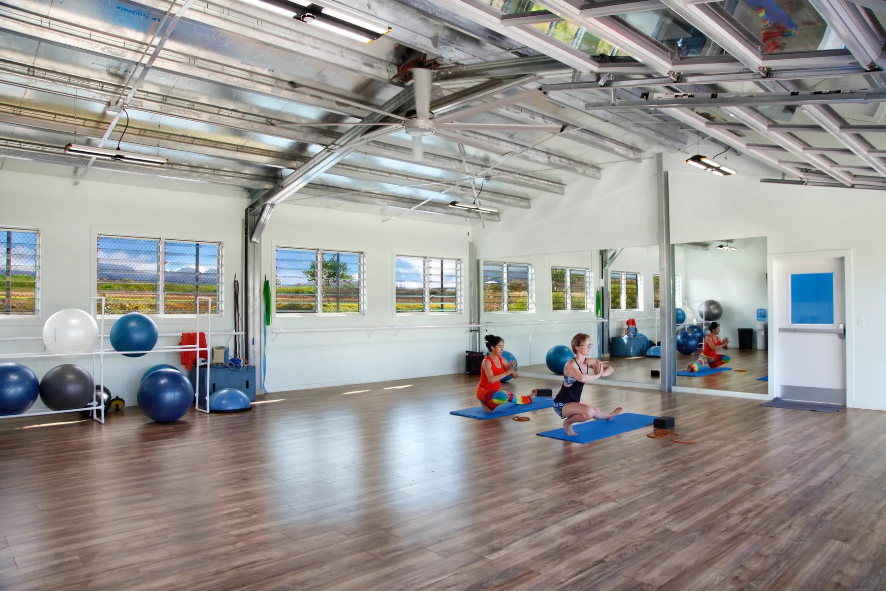 Un estudio de ejercicio luminoso con colchonetas y equipo de entrenamiento.