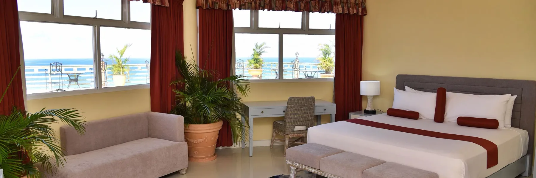 Habitación deluxe con vistas al mar, cama king, sofá pequeño y escritorio