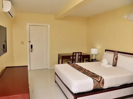 Habitación estándar con cama, televisor montado en la pared y escritorio de trabajo