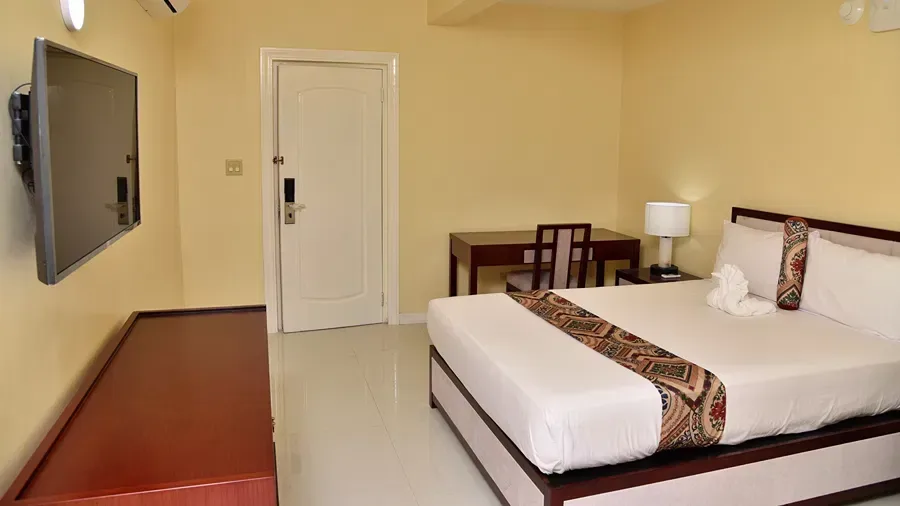 Habitación estándar con cama, televisor montado en la pared y escritorio de trabajo