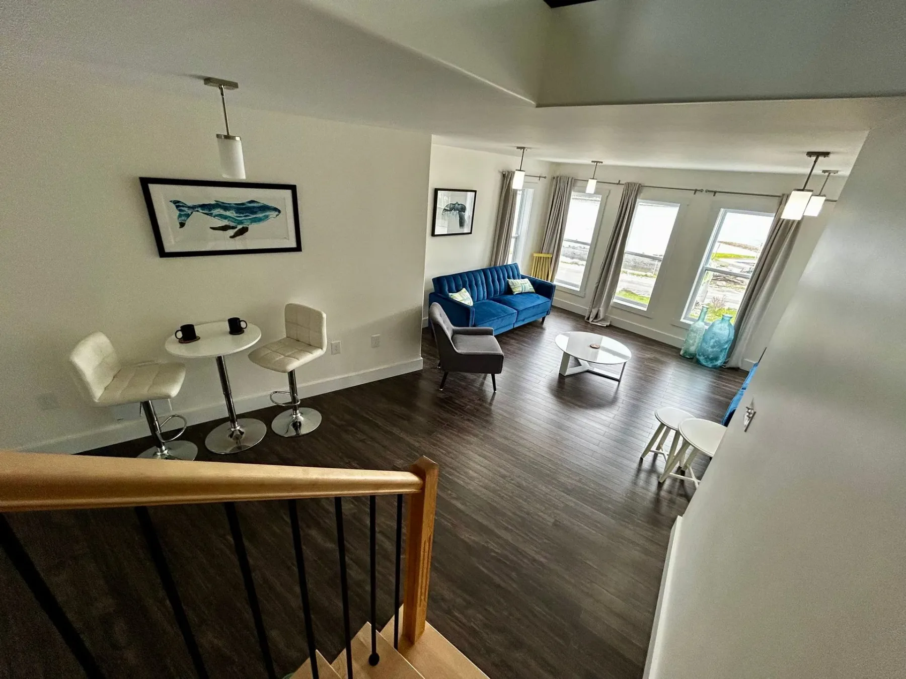Living room with blue couch, table, chairs, and stairs