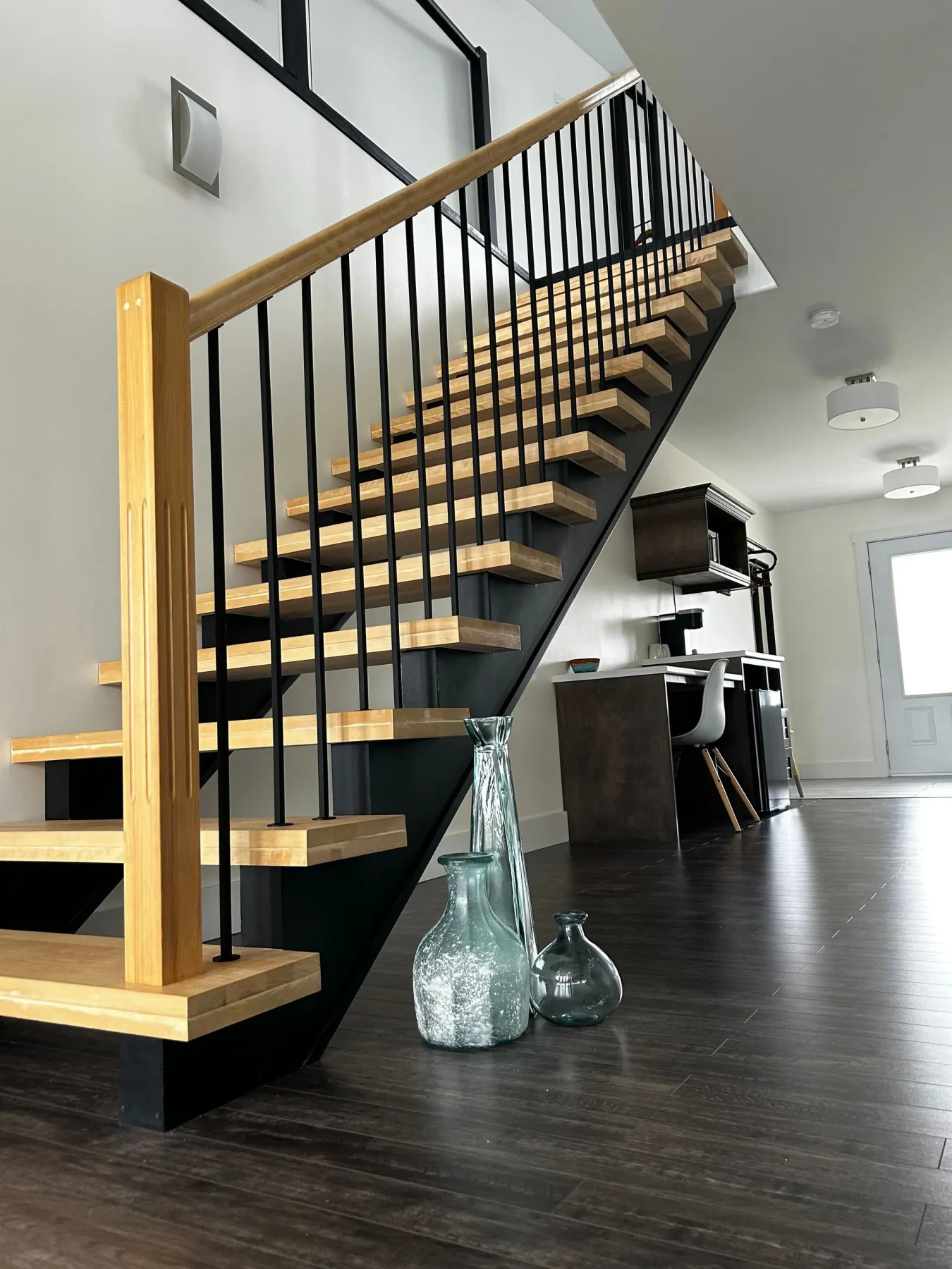 Wooden staircase with black railing in a living room