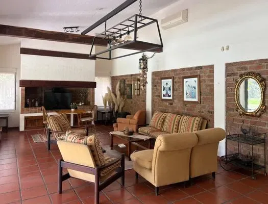A living room with seating, a television, and brick accent walls.