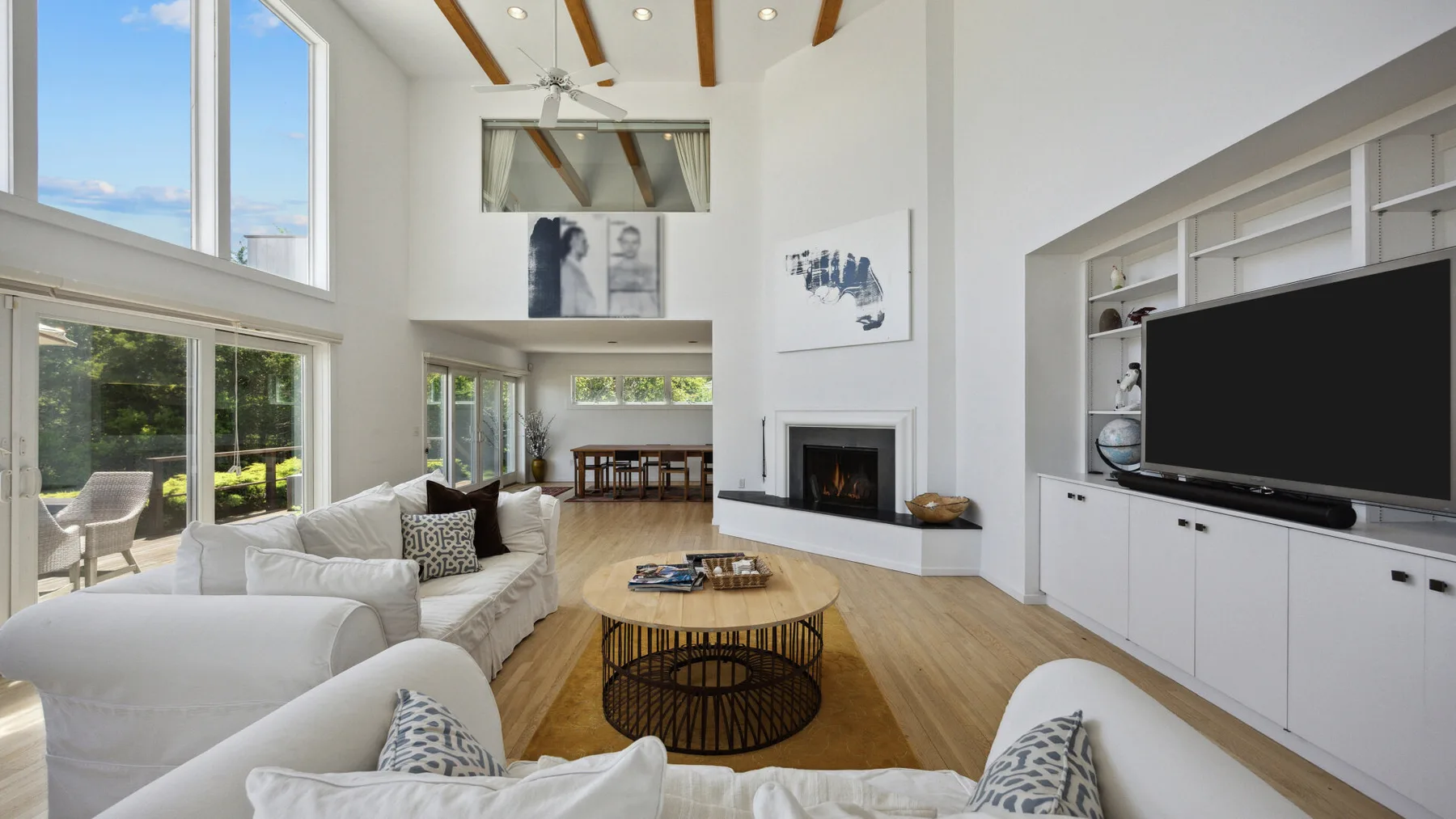 A bright living room with seating around a coffee table and a fireplace.