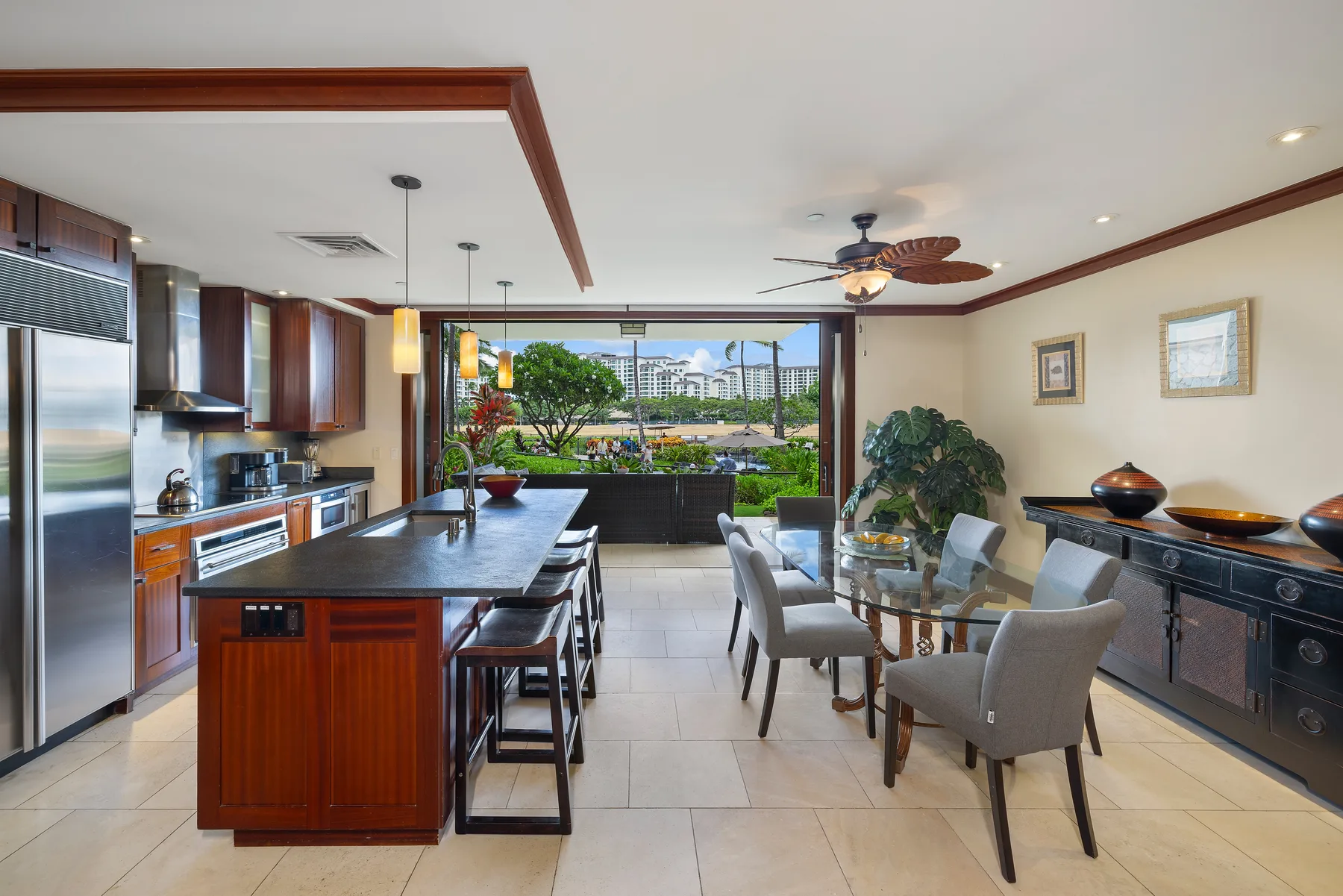 Una amplia cocina y comedor con una isla central y una mesa de comedor de vidrio.
