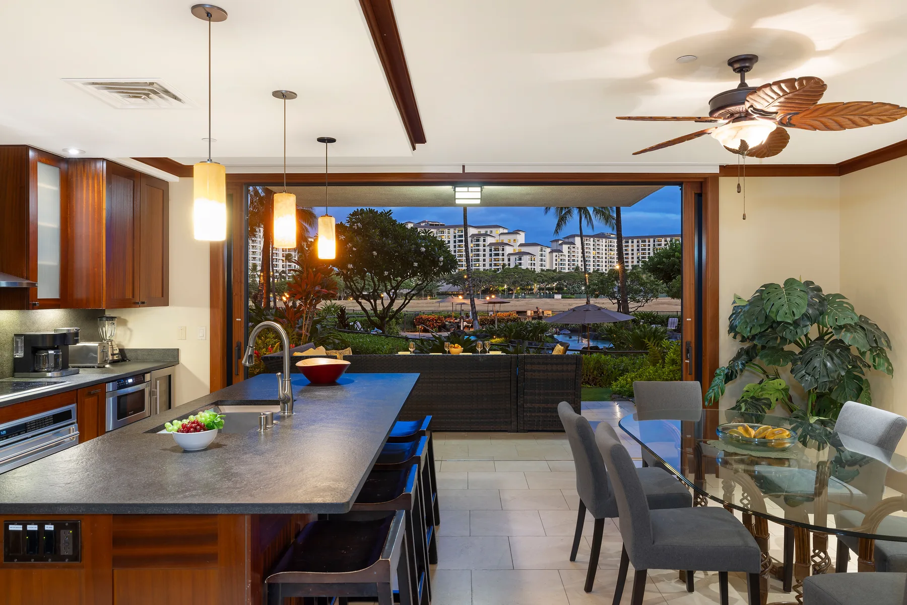 Una cocina abierta y zona de comedor con una amplia vista de vegetación y edificios al exterior.