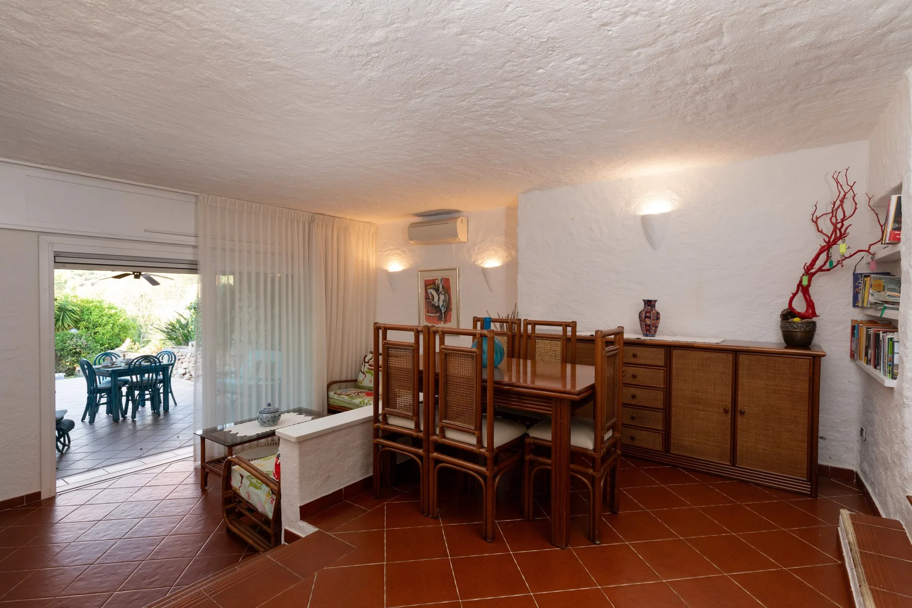 A dining area with wooden tables and seating beside an open patio.
