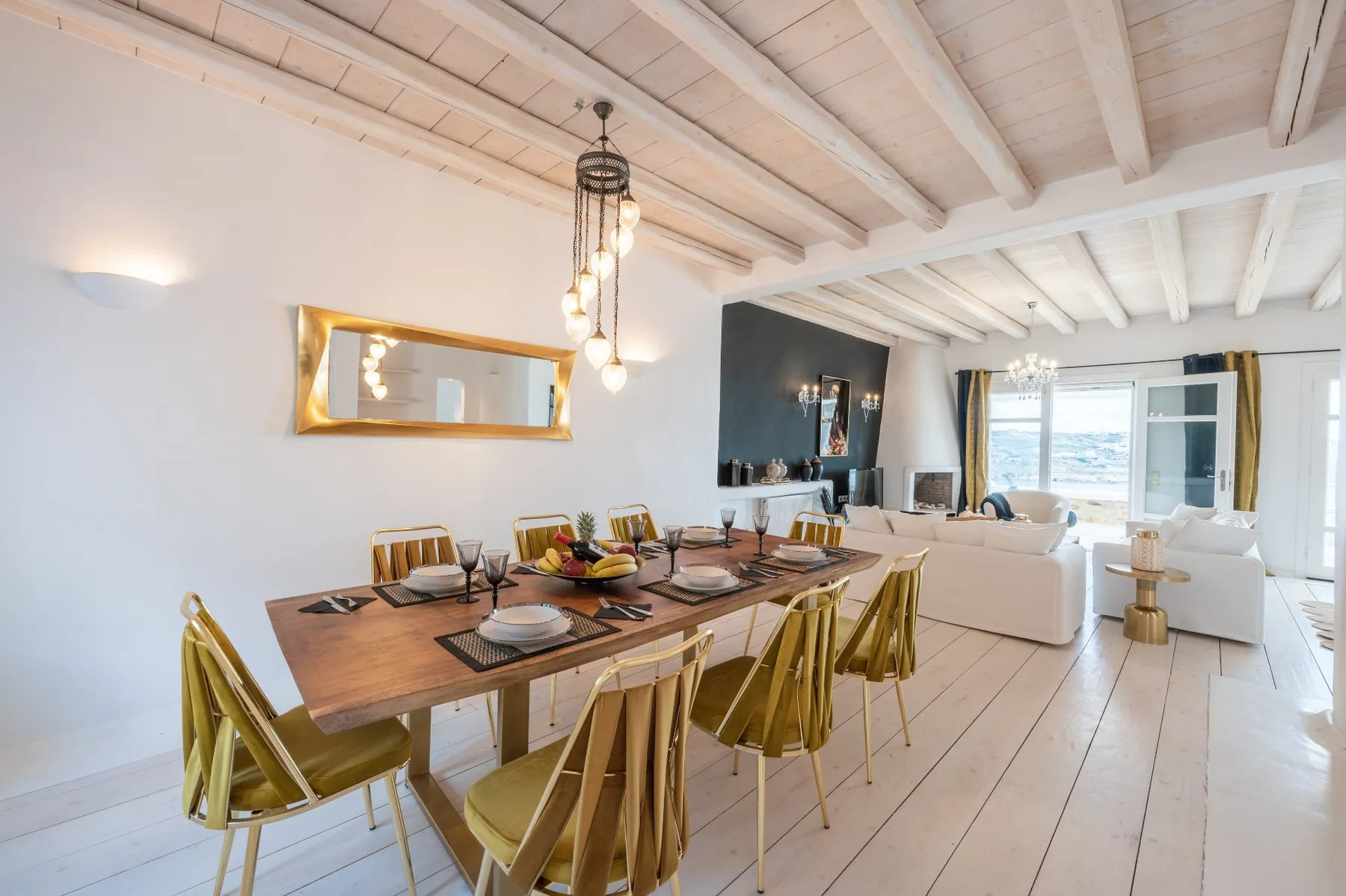 A dining area with a wooden table and seating beside a bright living space.