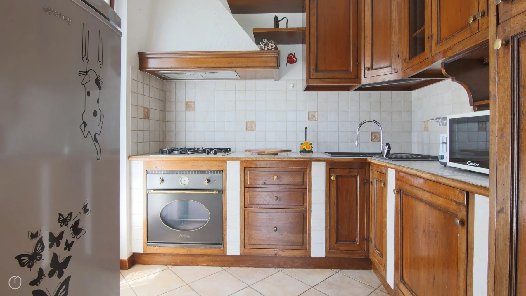 A kitchen with wooden cabinets, a tiled backsplash, and an oven.
