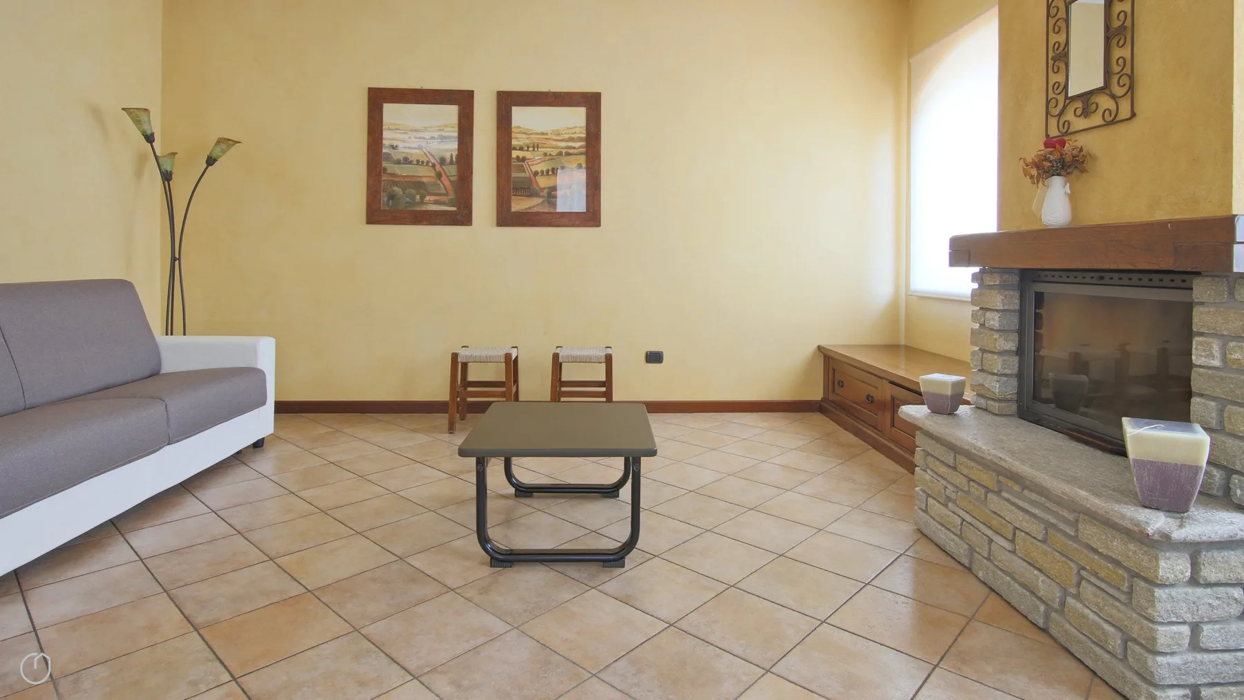 A living room with seating, a small table, and a stone fireplace.