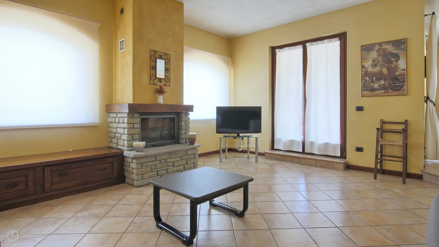 A living room with a brick fireplace and a television.