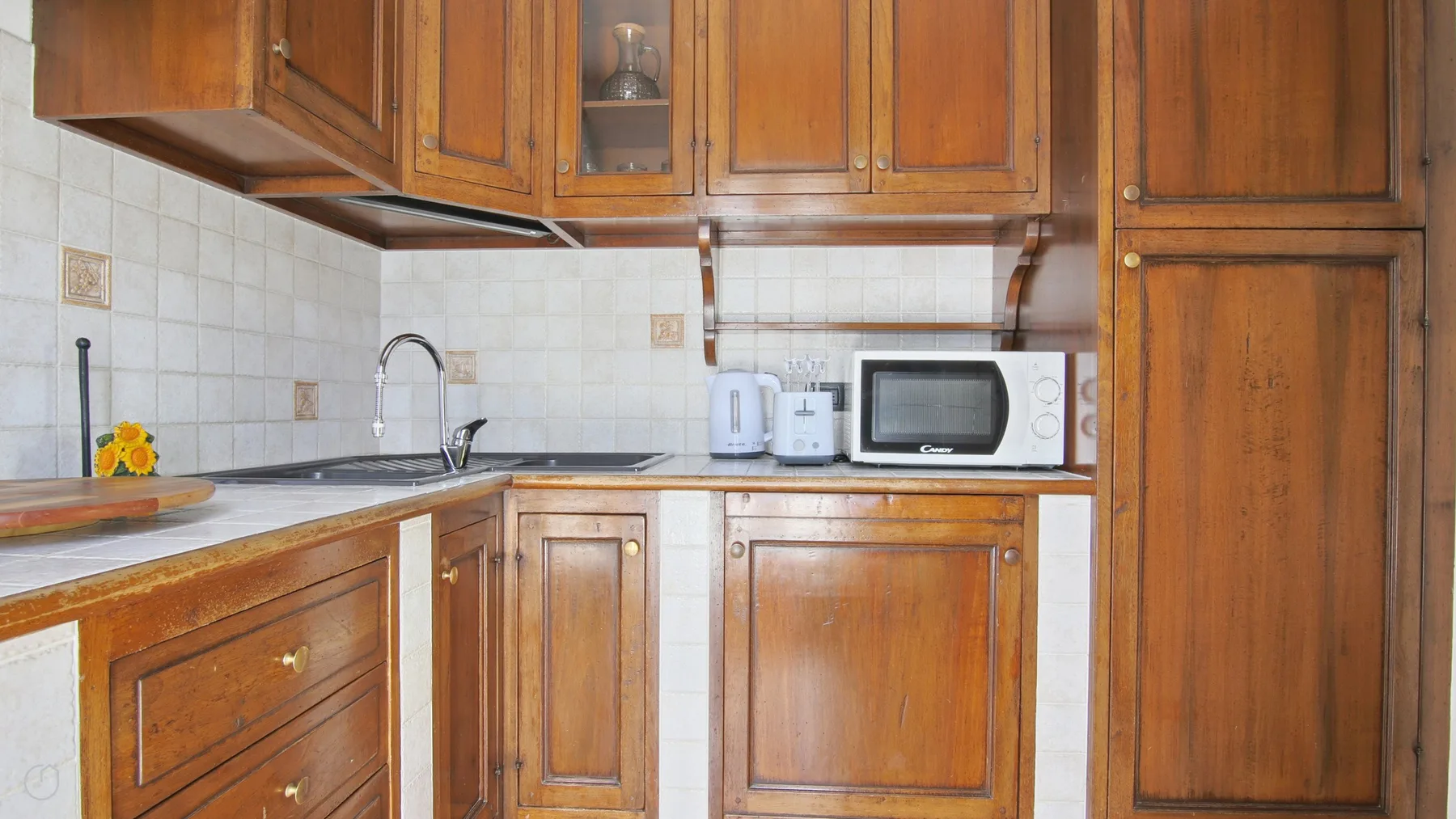 A kitchen with wooden cabinets, a sink, and countertop appliances.