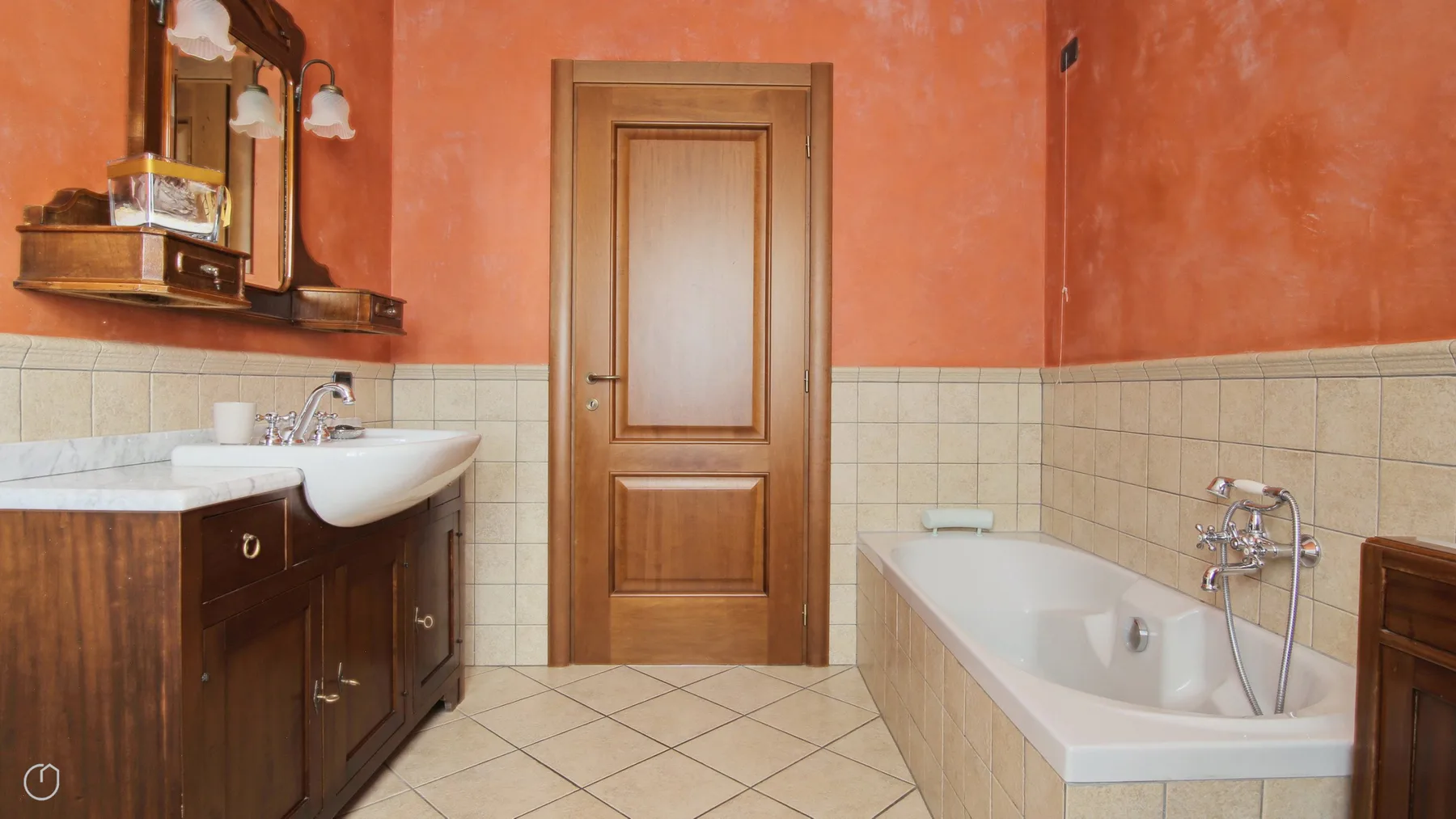 A bathroom with a wooden vanity, sink, and bathtub.