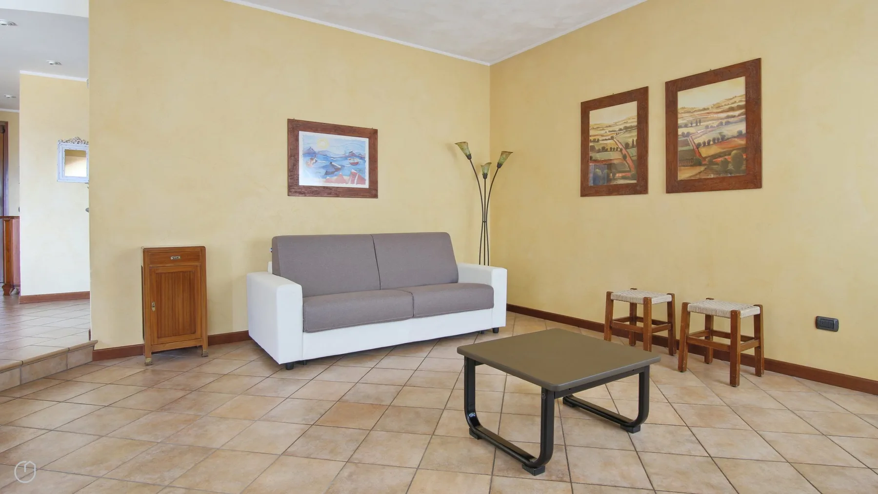 A living room with a sofa, coffee table, and framed wall art.
