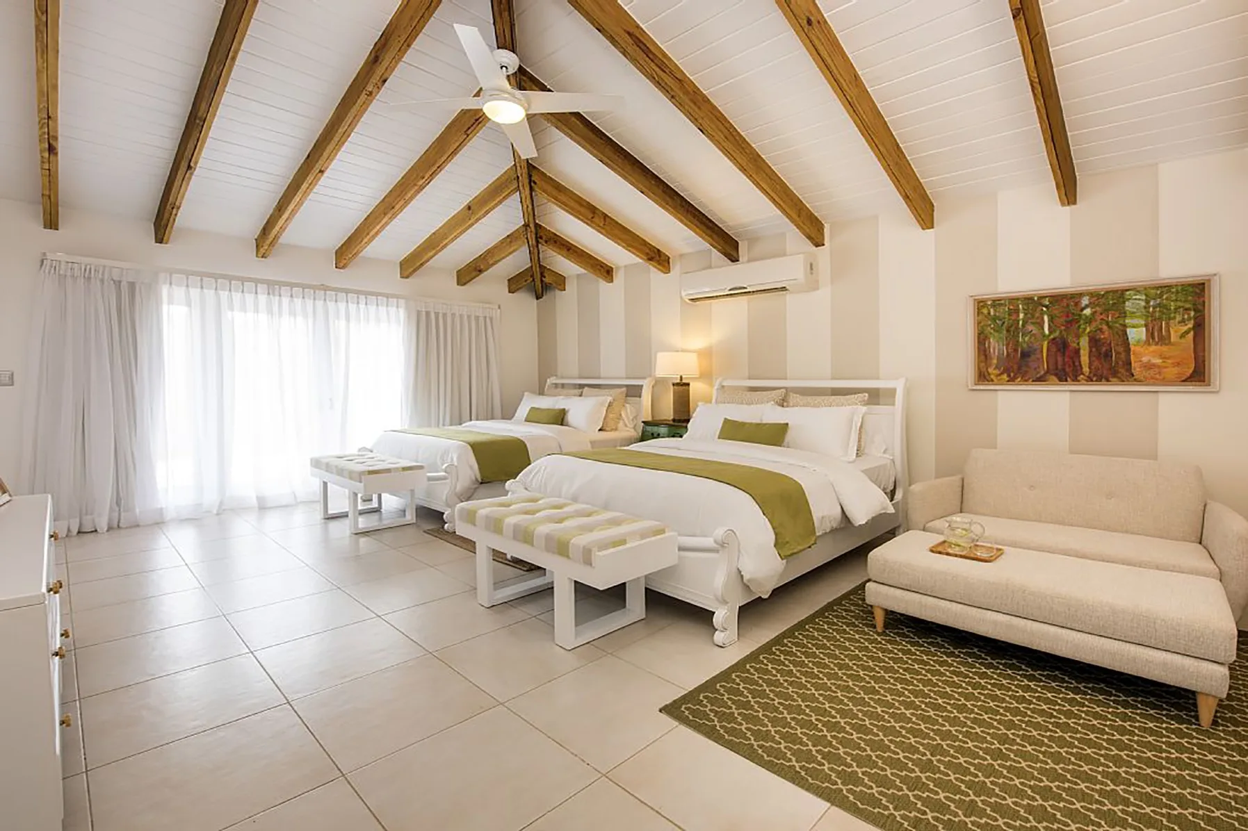 Un dormitorio luminoso con dos camas bajo un techo con vigas de madera.