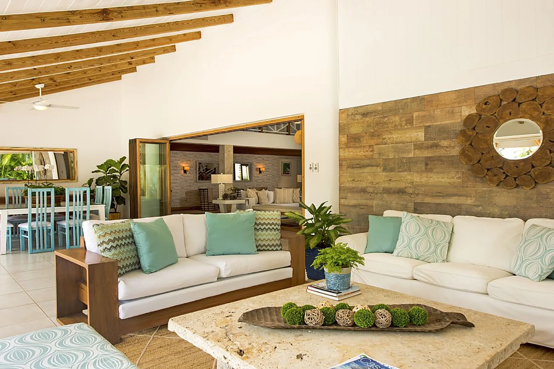 A bright living room with sofas, a coffee table, and exposed ceiling beams.