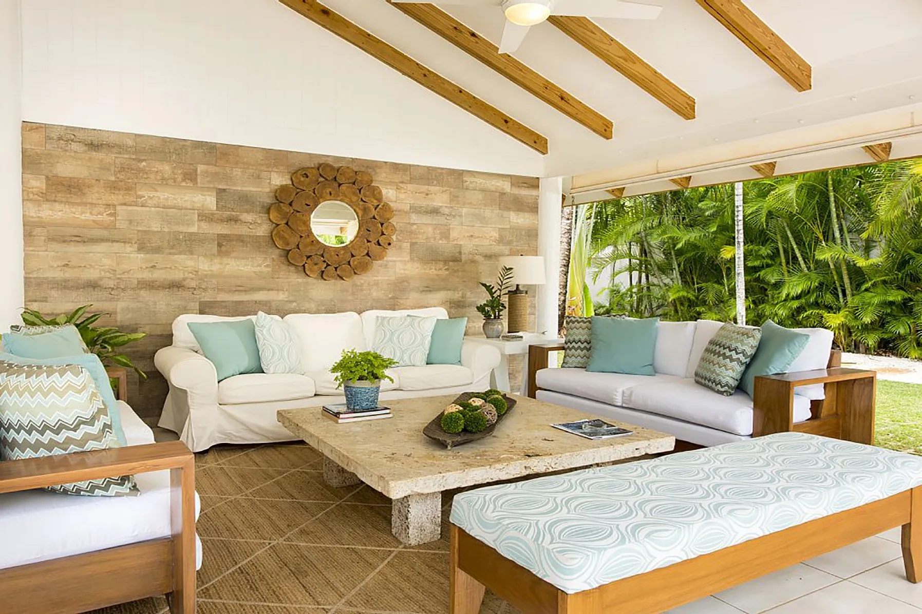 An open-sided living room with cushioned seating and a coffee table.