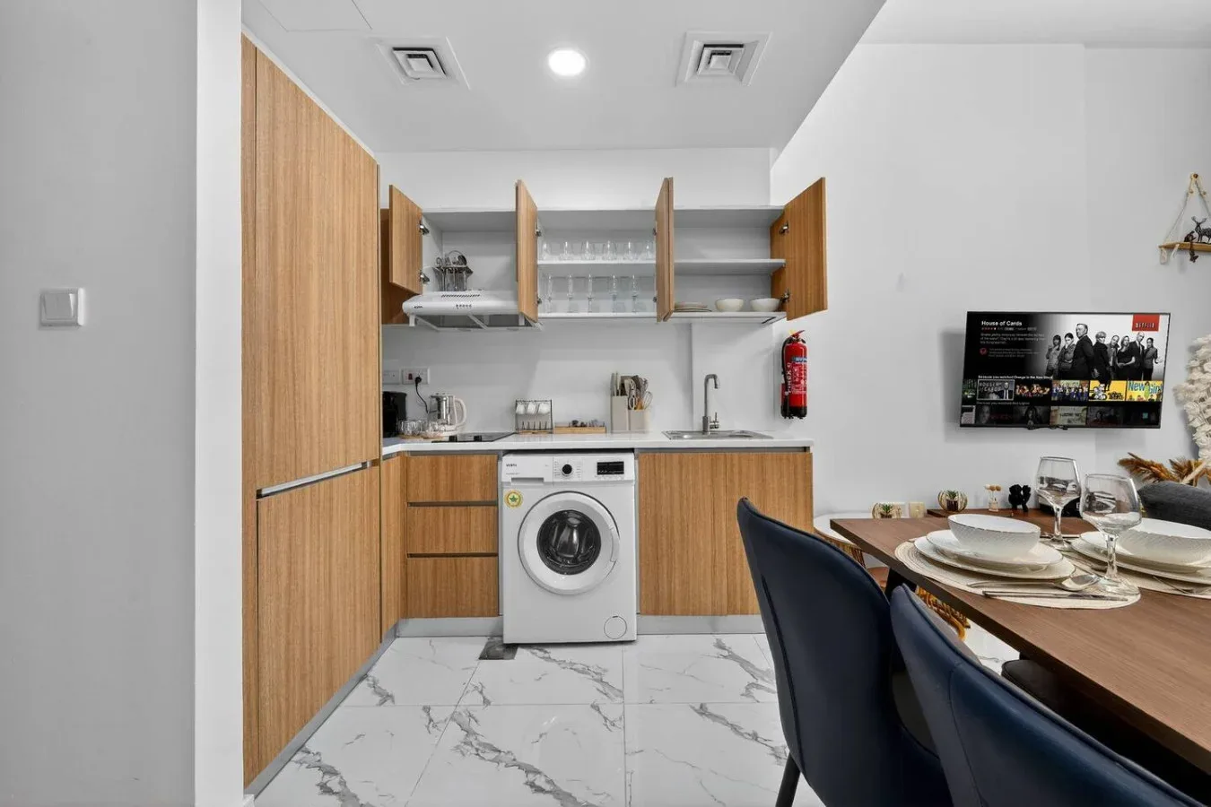 A compact kitchen and dining area with wood cabinets and a set table.