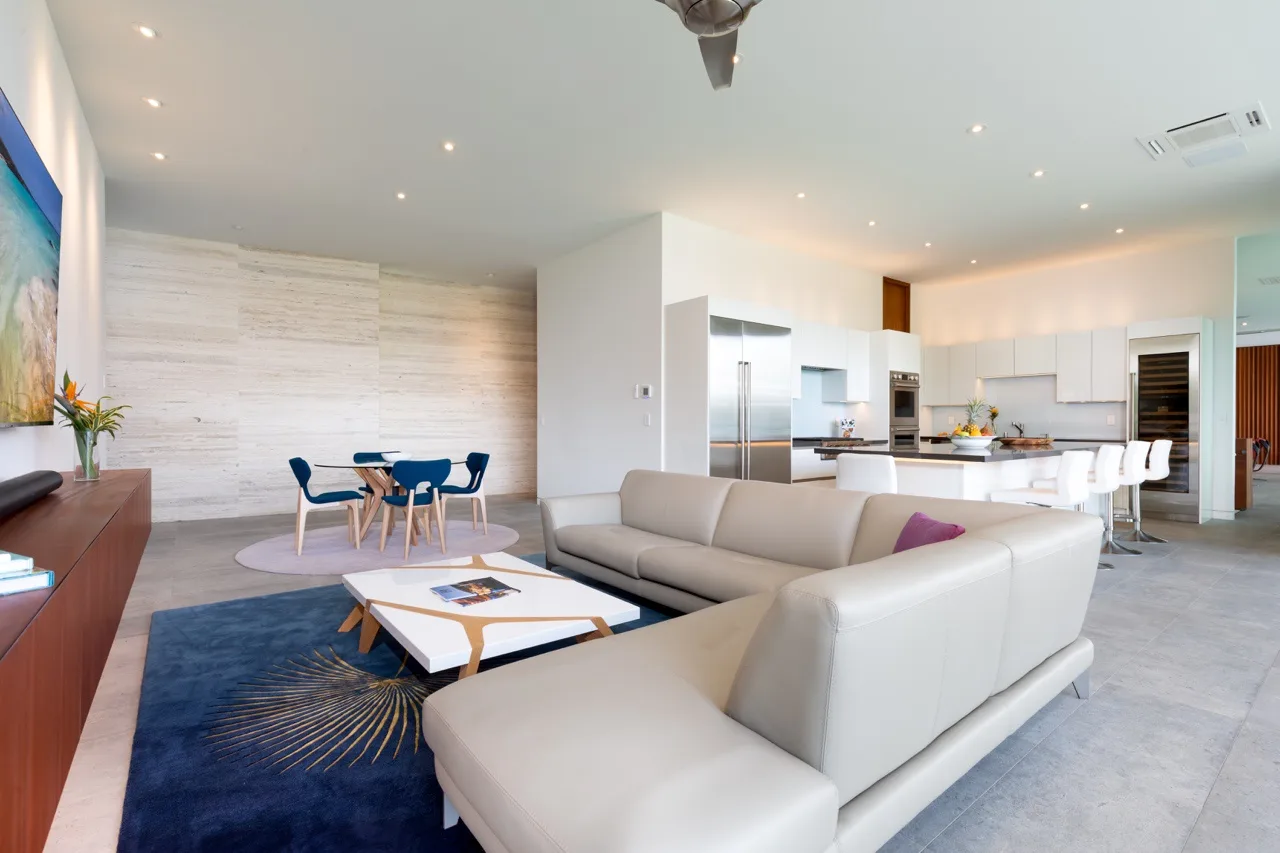 An open-plan living and dining area with a kitchen and light-colored seating.