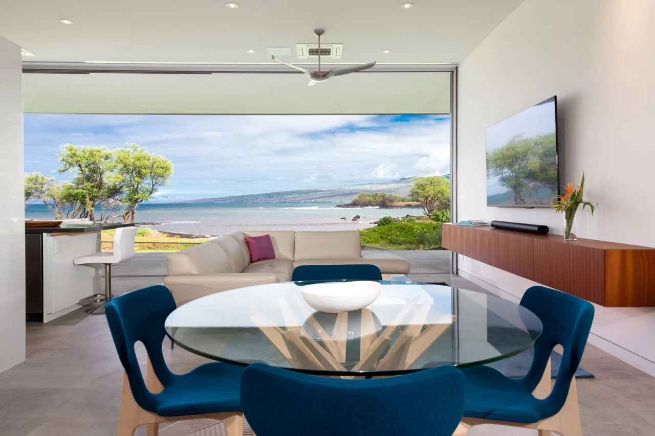 A bright living and dining area opens onto a view of the ocean.