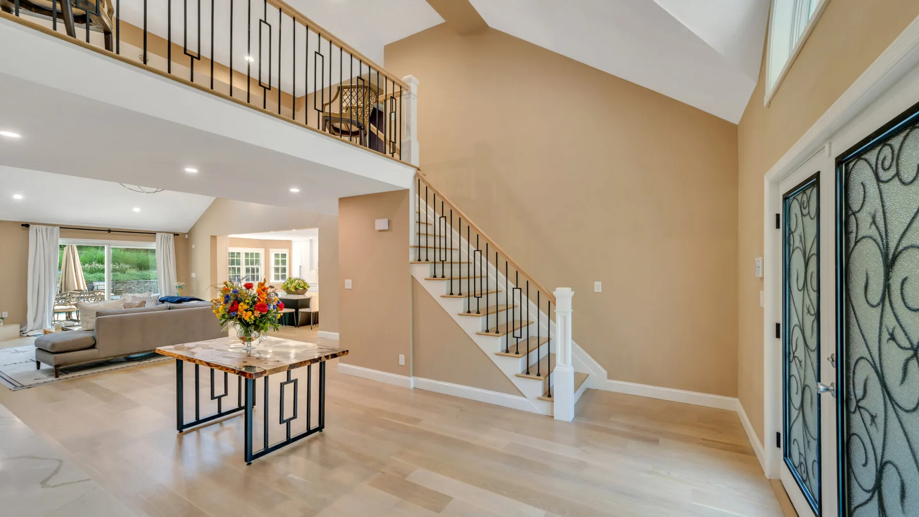 A spacious living room with a staircase and dining table.
