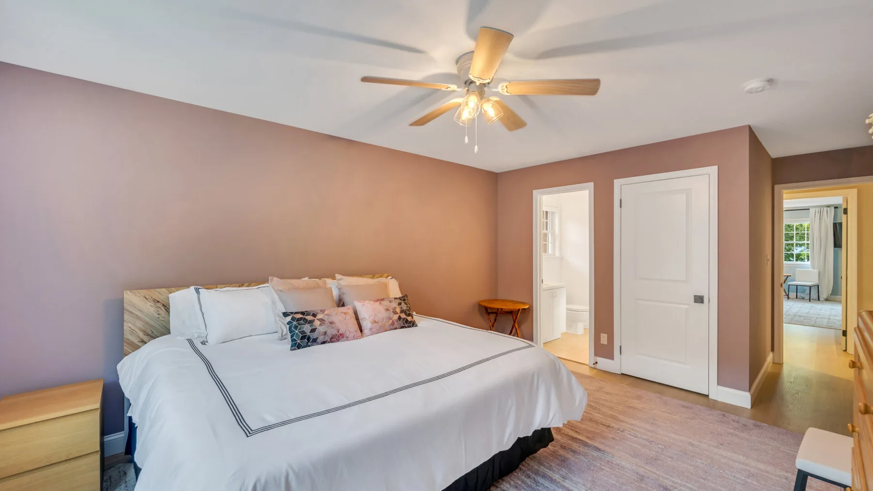A bedroom with a large bed and a ceiling fan.