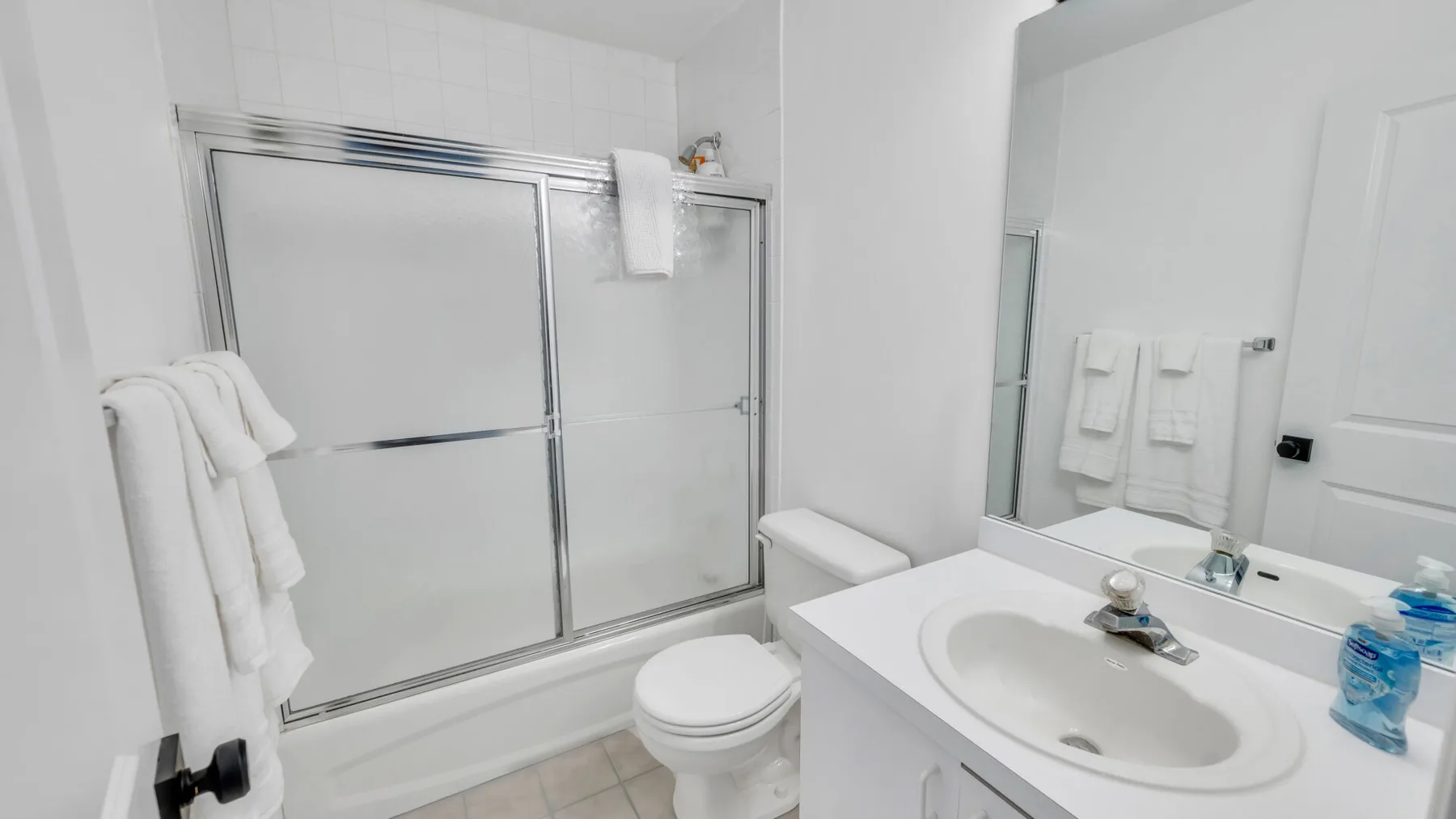 A bright bathroom with a bathtub, shower, and sink.