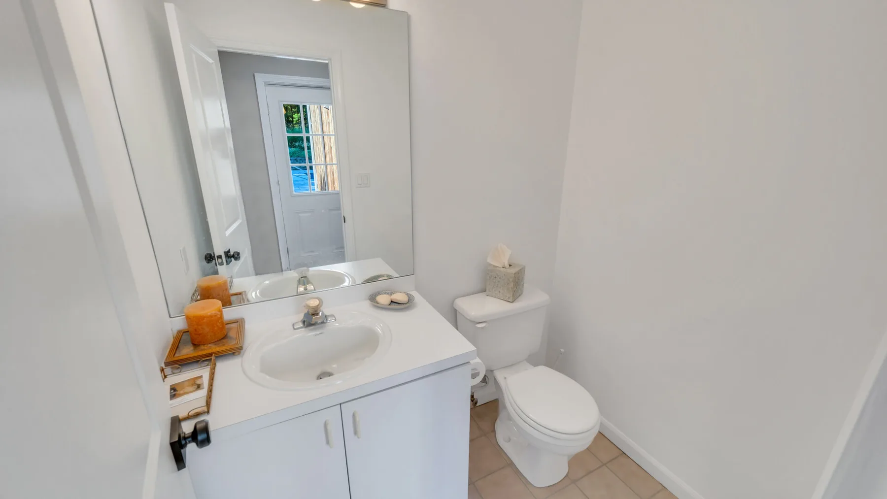 A bright bathroom with a white sink vanity and toilet.