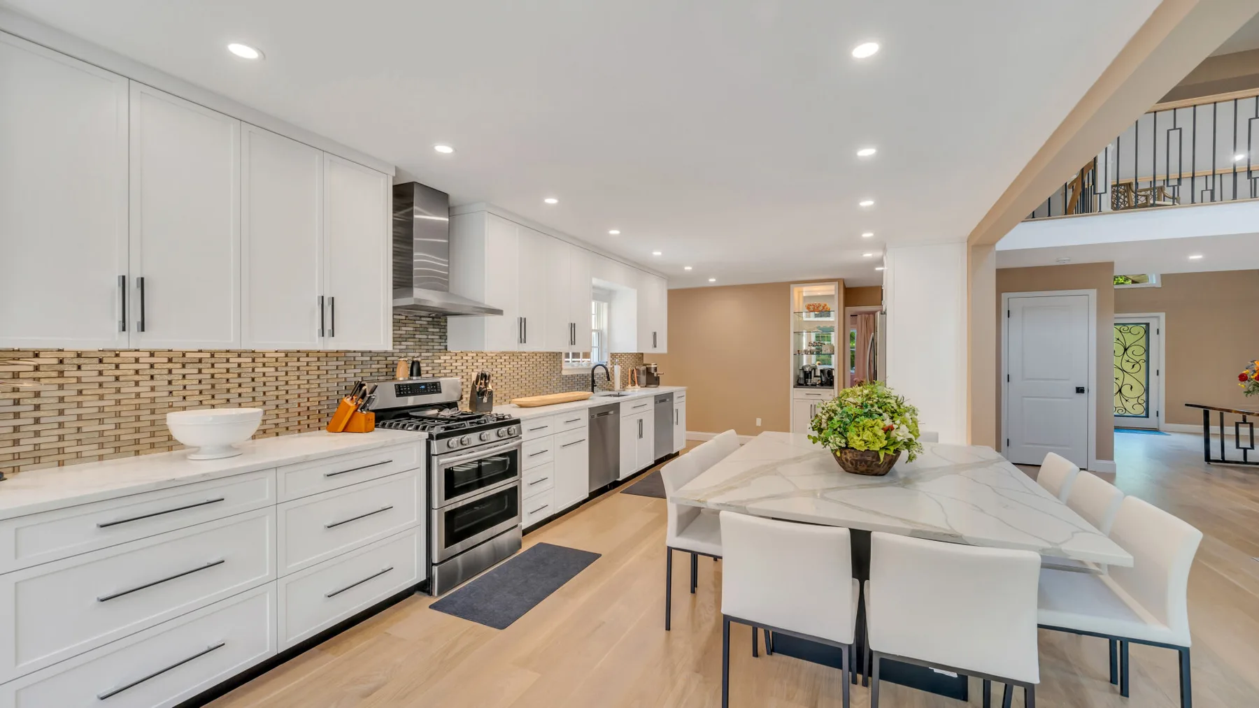 A bright kitchen and dining area with white cabinetry and a table.