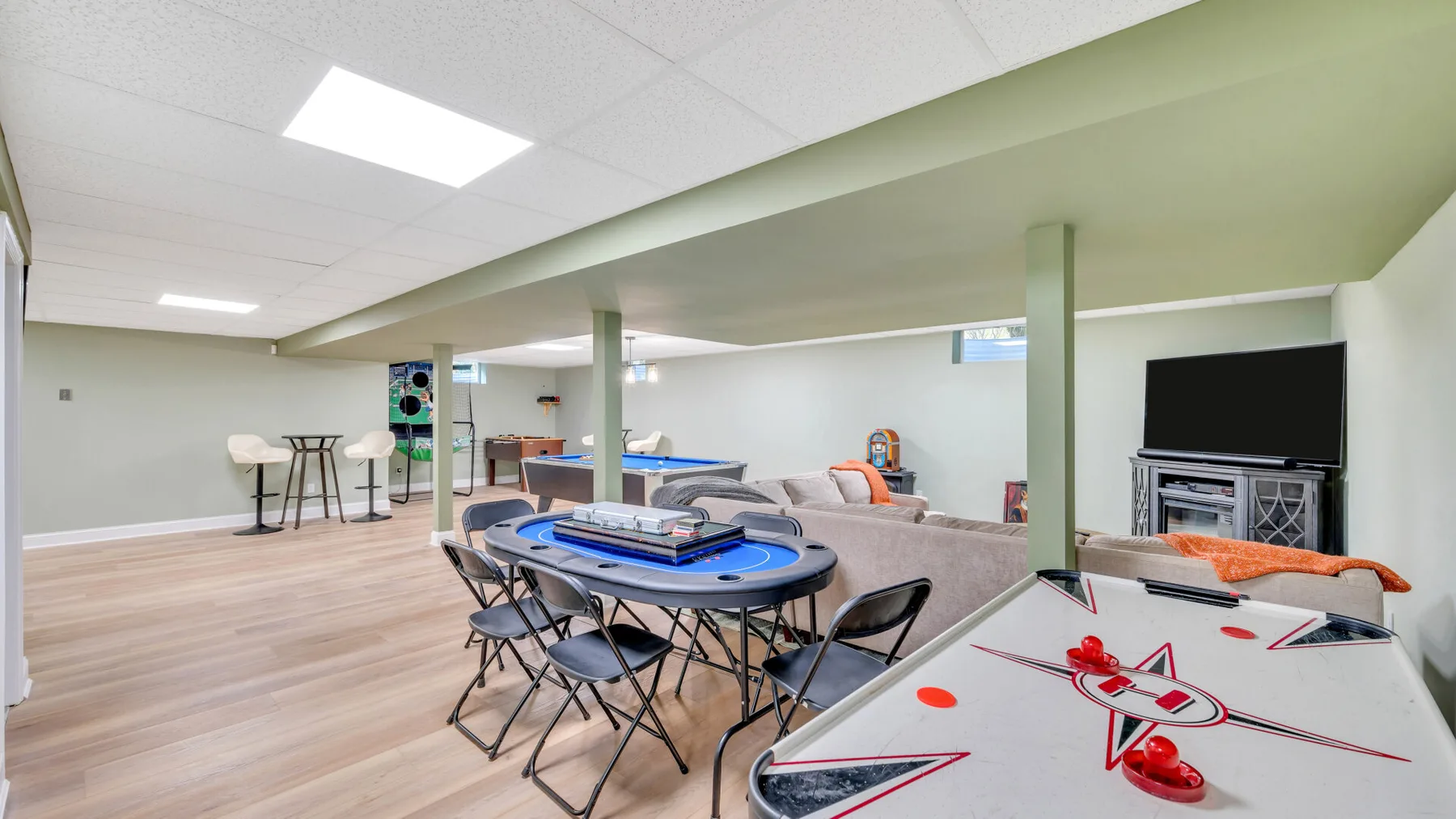 A recreation room with tables, seating, and a television.