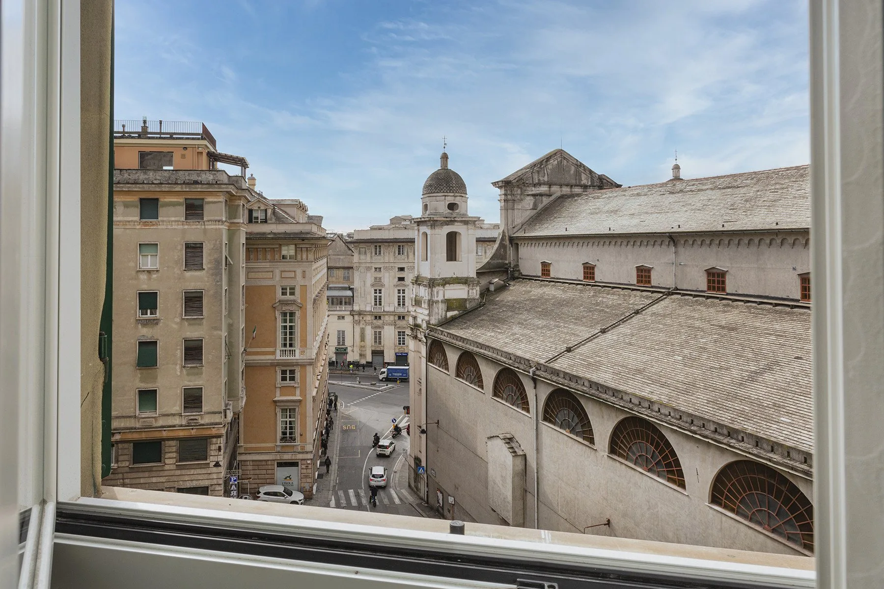 A city street and historic buildings are visible through an open window.
