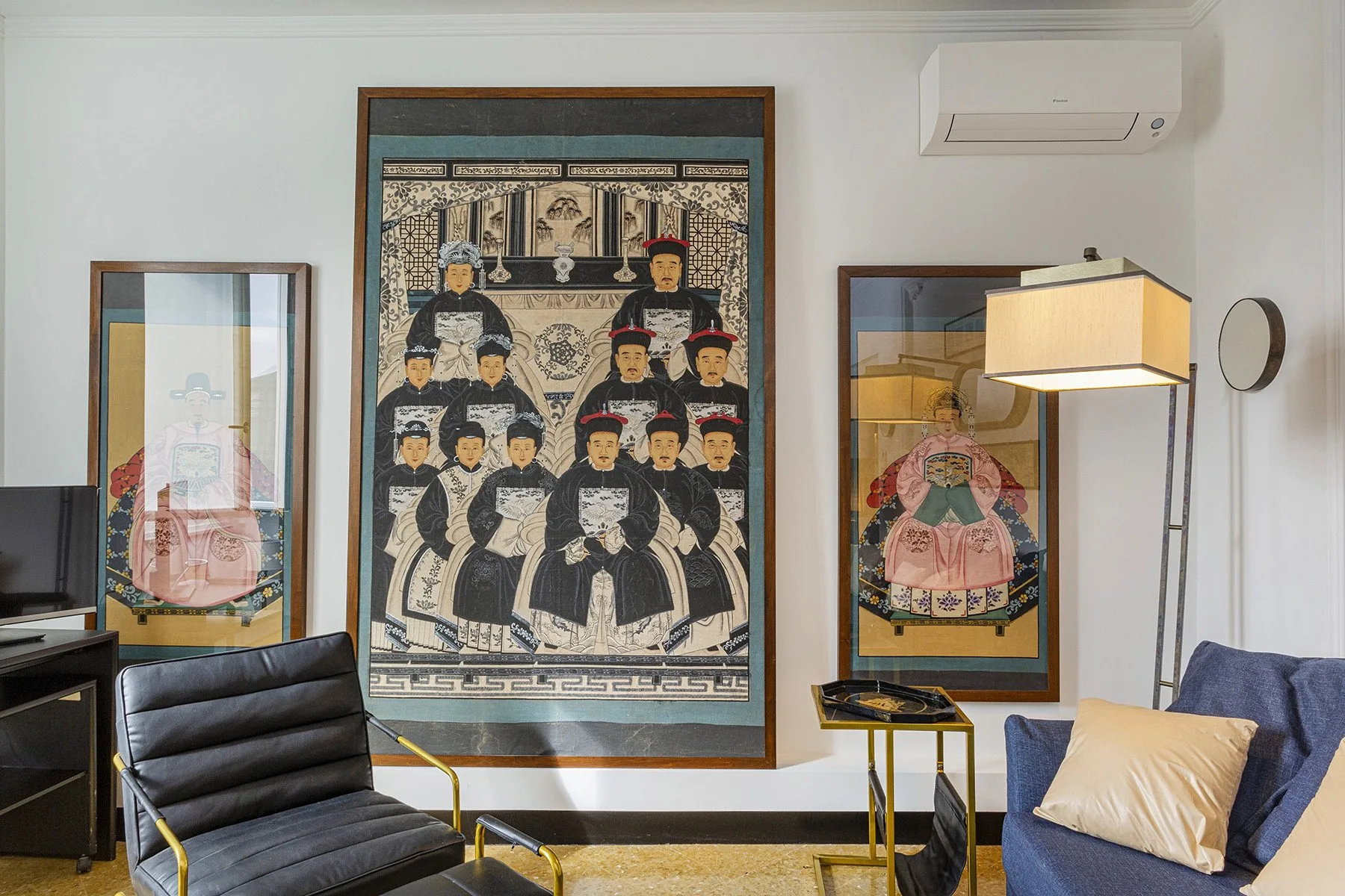 A living room with framed artwork, seating, and a floor lamp.