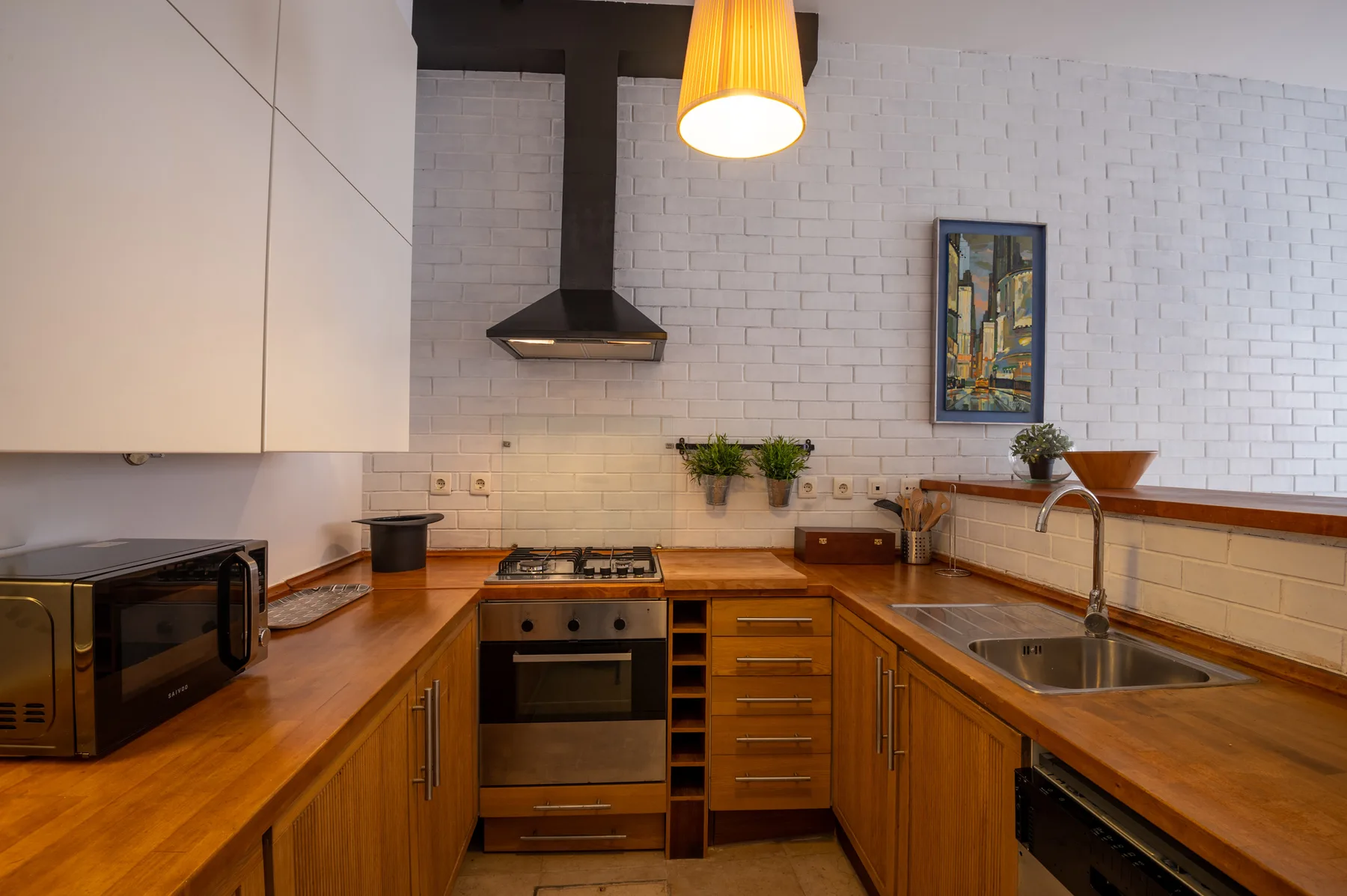 A kitchen with wooden countertops and built-in cooking appliances.