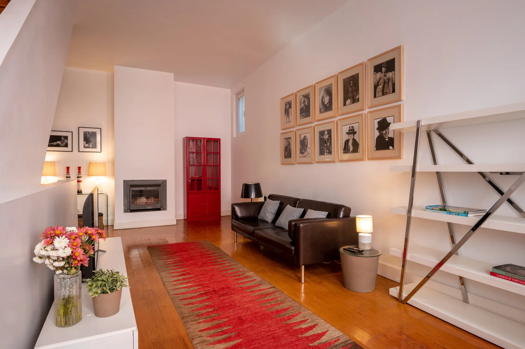 Living room with dark seating, a fireplace, and framed artwork.
