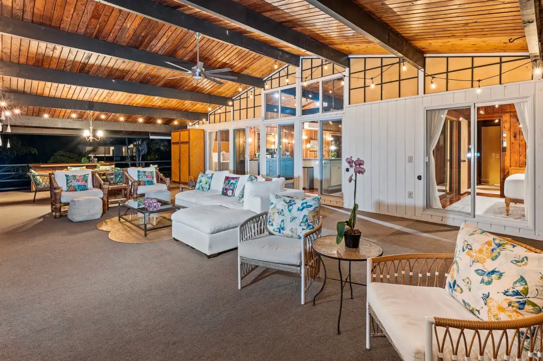 A covered patio with seating and glass doors opening onto the interior.