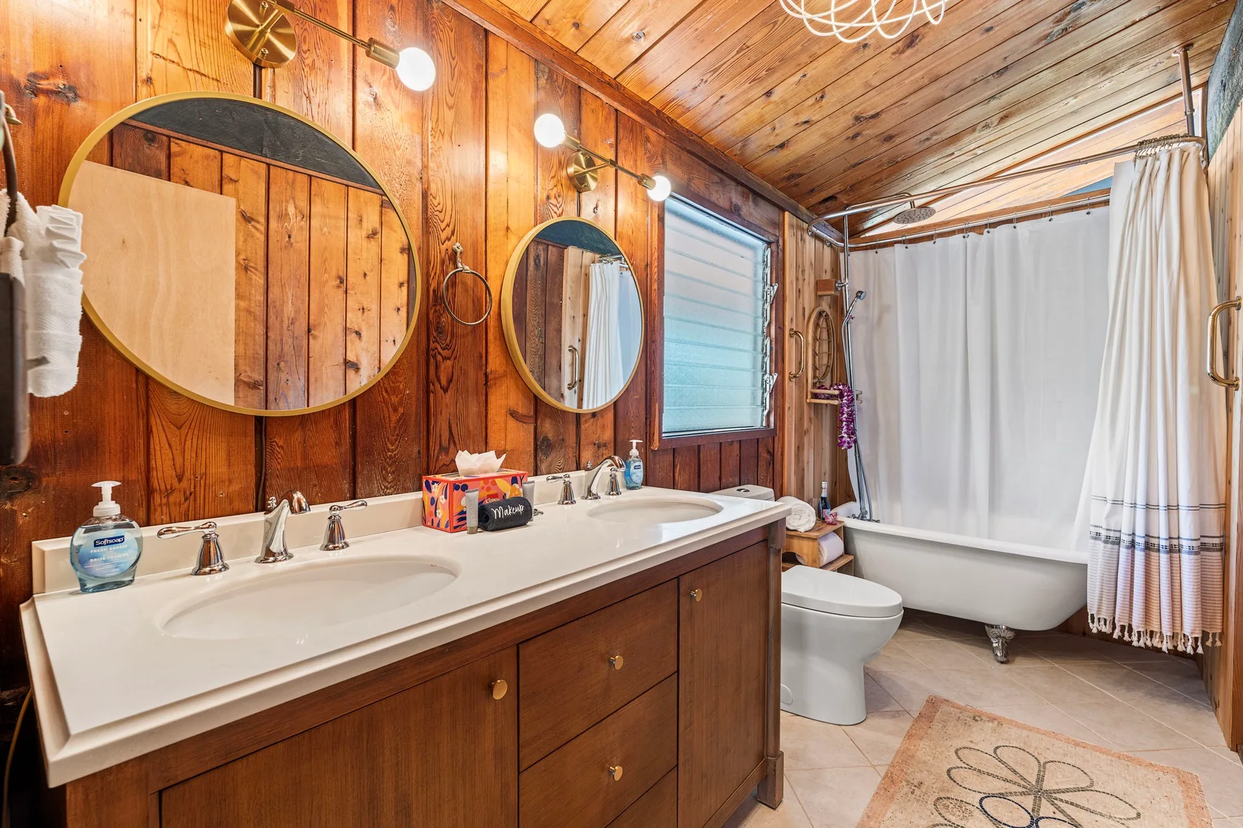 A wood-paneled bathroom with a long vanity and a bathtub behind a curtain.