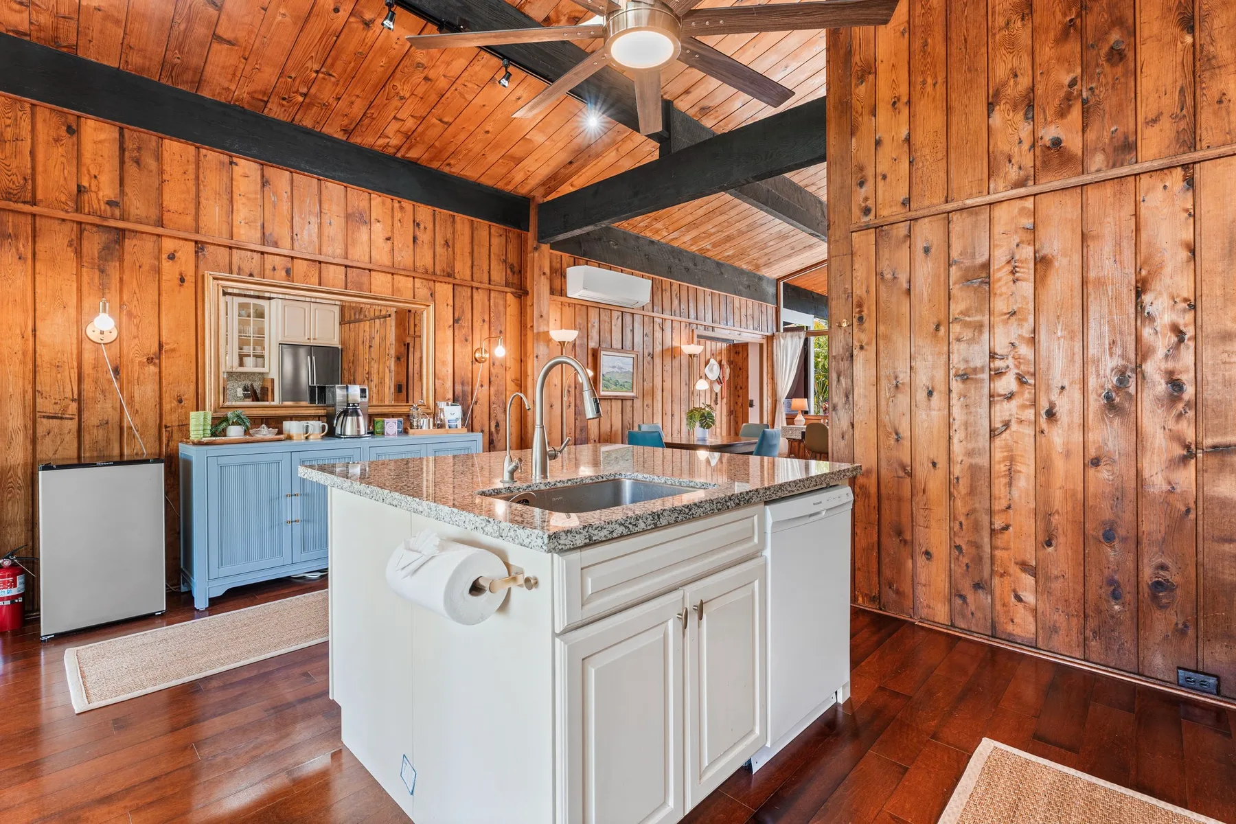 A wood-paneled kitchen with a central island and sink.