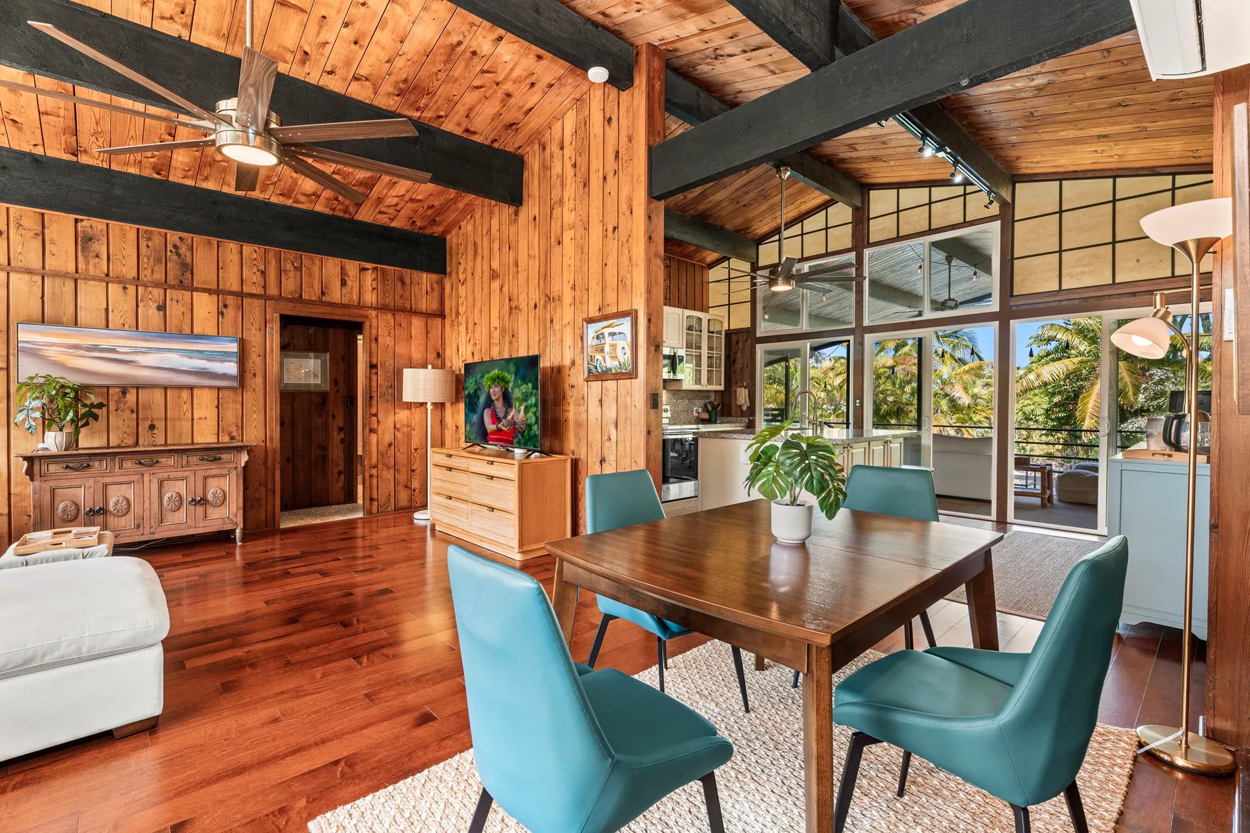 A spacious wood-paneled living and dining area with a table and large windows.